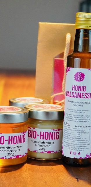 Bio-Honig Bio-Imkerei Bienenkönig Niederrhein Gläser mit Bio-Honig in verschiedenen Sorten auf einem Holztisch.